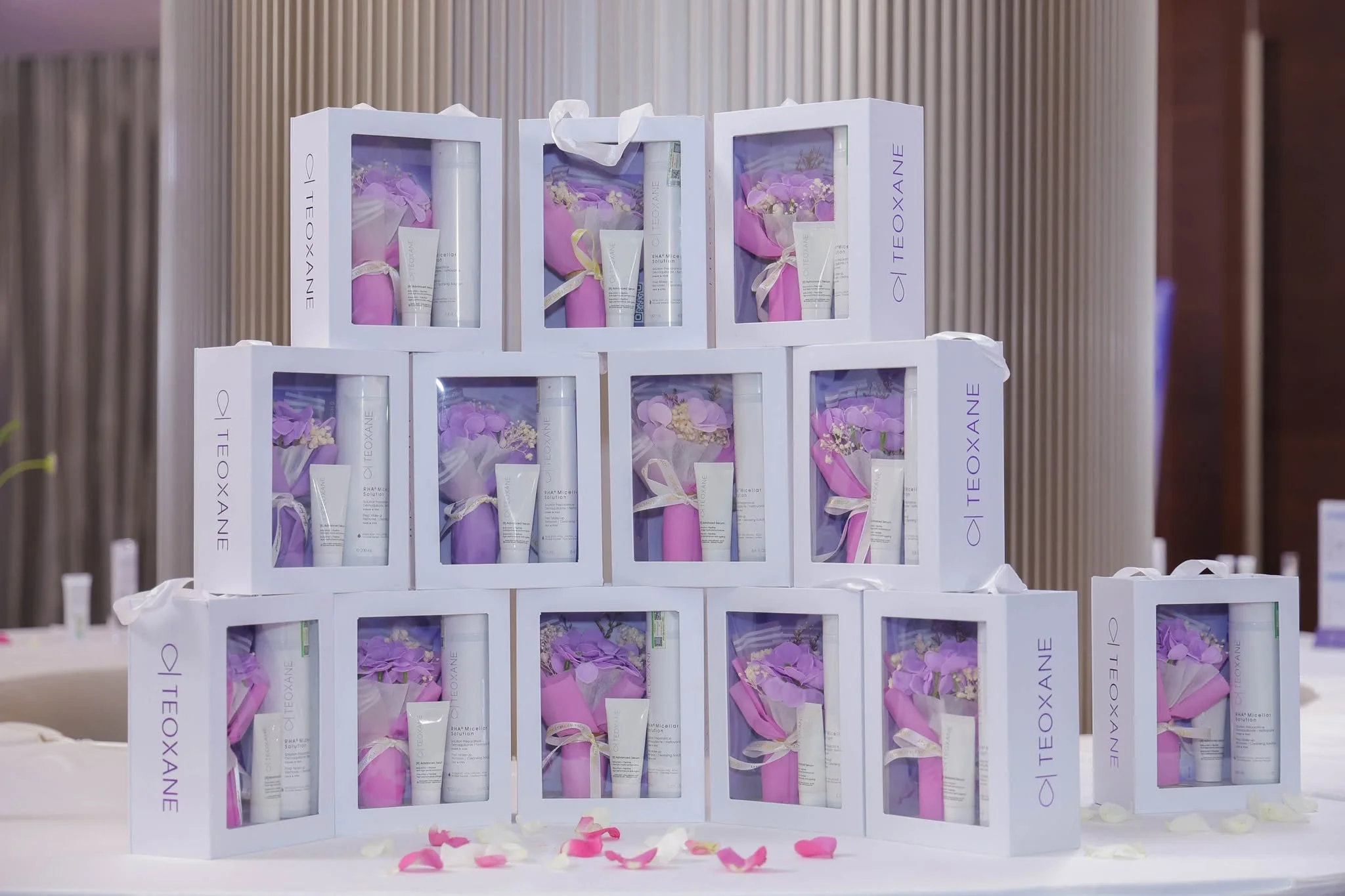 Stacked TEOXANE gift boxes with lavender bouquets