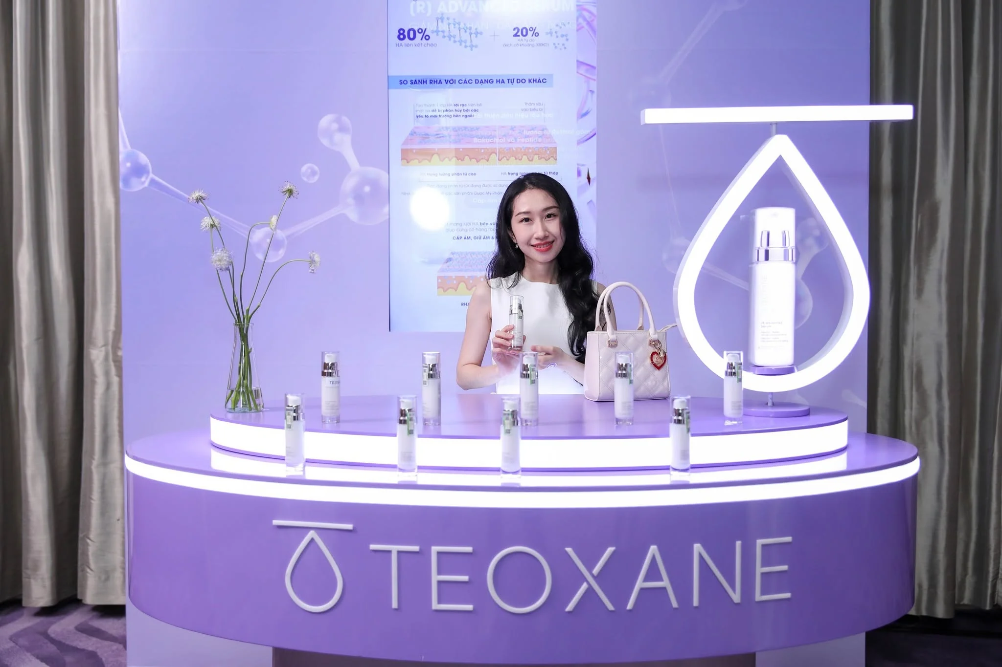 Guest holding a TEOXANE serum at the illuminated drop-shaped display