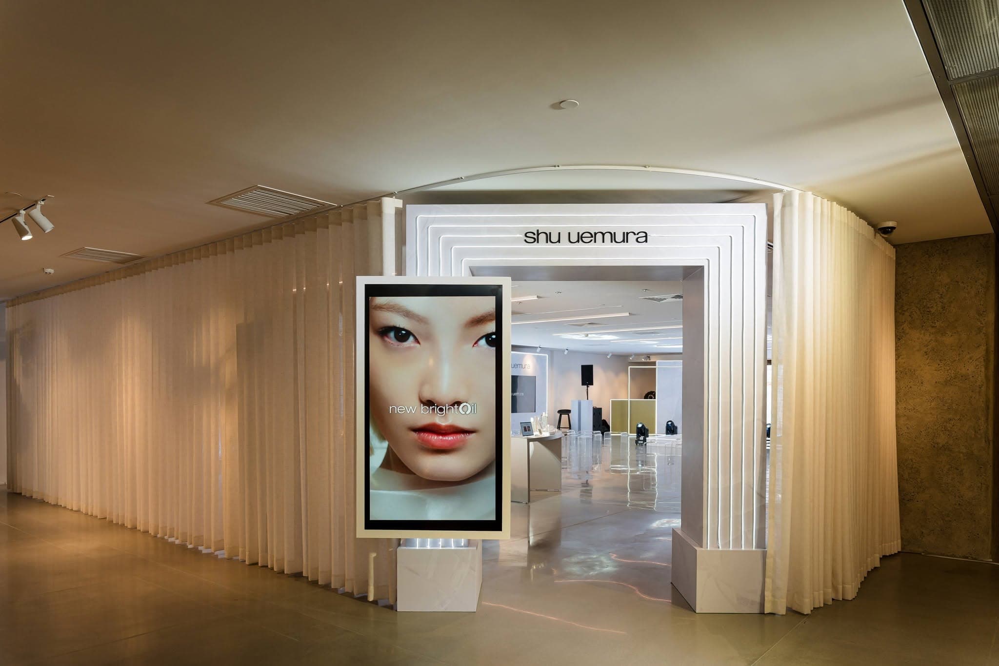 shu uemura brightOil bottle showcase with gold light accents
